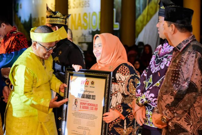 
 Bupati Bengkalis Kasmarni saat menerima piagam penghargaan dari ketua PWI Pusat Atap Depari