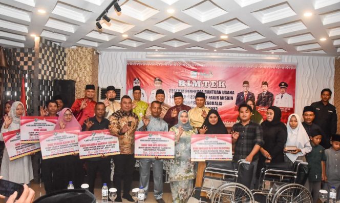 
 ? Bupati Bengkalis Kasmarni dan Wabup H Bagus Santoso foto bersama peserta Bimtek dan penerima Bantuan Sosial.