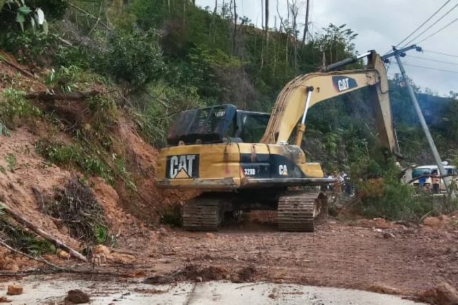 
 ?  Alat berat sedang melakukan pembersihan material longsor yang menutupi jalan.(Sumber: Media Center Riau)