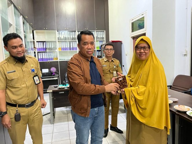 
 Plt. Kadis PMD Ismail saat memberikan kenang-kenangan kepada pegi Purna Bakhti Basma Khairani