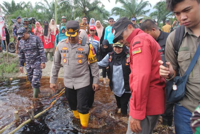 
 ? Kapolres Bengkalis bersama Bupati dan rombongan saat mengecek lokasi banjir di Kecamatan Siak Kecil.