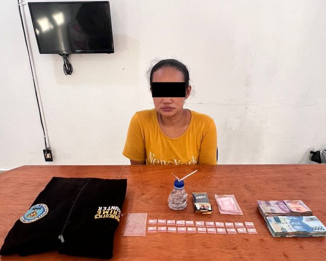 
 ? Tersangka EH (37) bersama barang bukti.