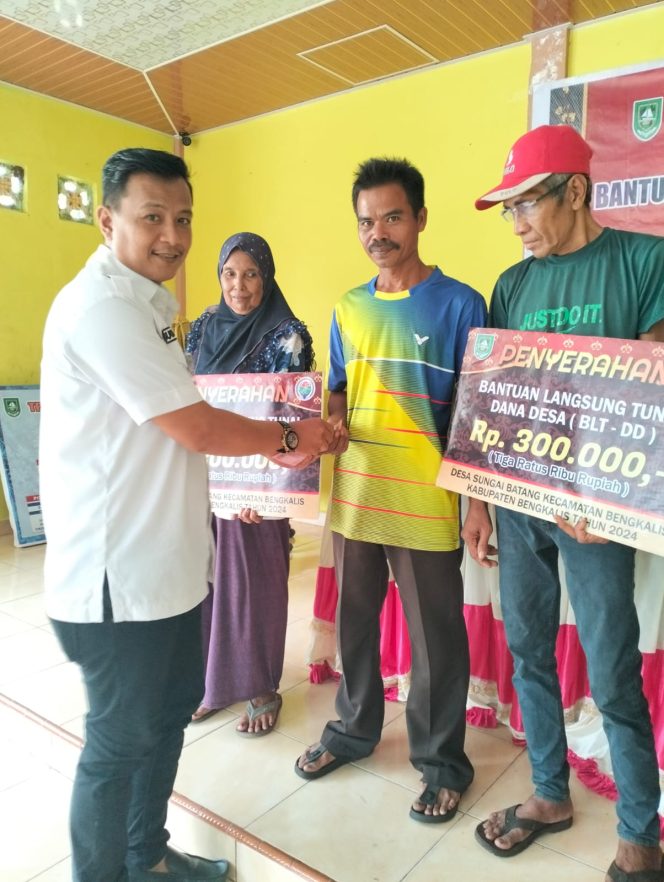 
 Pj. Kepala Desa Budiman SE, MM saat menyerah kan BLT DD