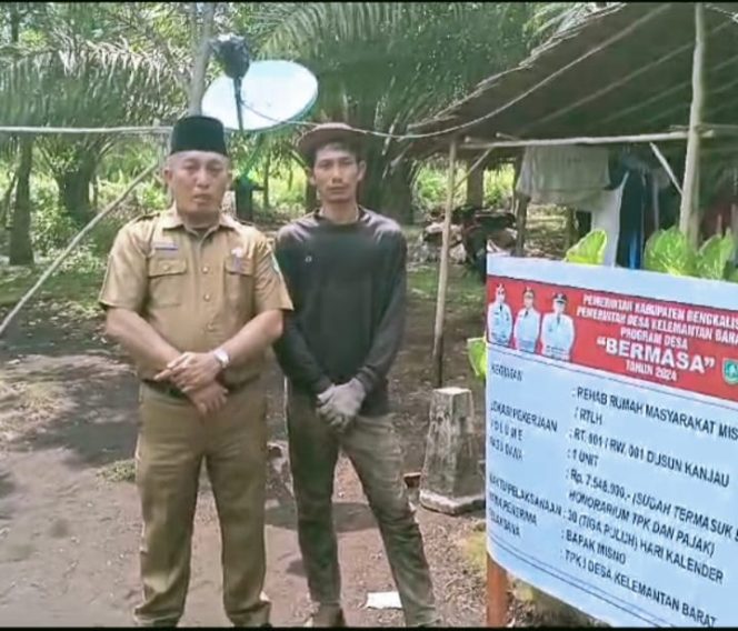 
 Pj. Kades Kelemantan Barat MHD. Nasir Rustam bersama Misno warga penerima program rehab rumah keluarga miskin