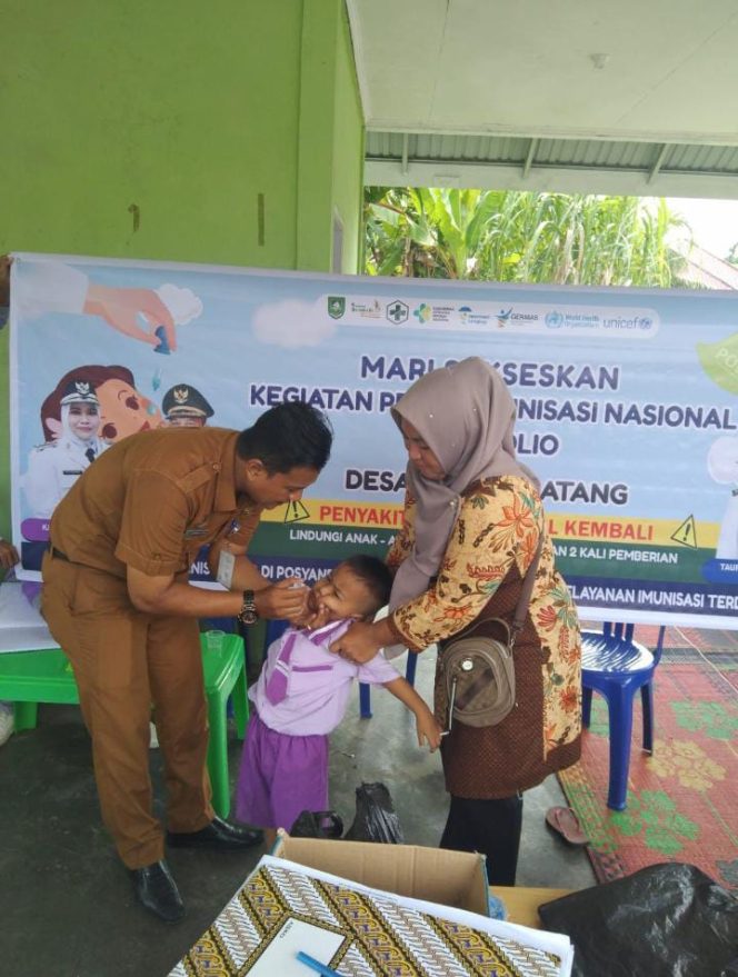 
 Budiman SE, MM bersama Ketua TP PKK saat memberikan pin Polio