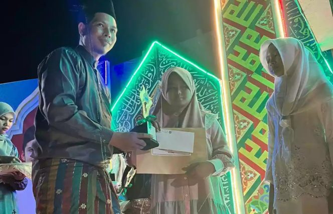 
 ? Sekretaris desa (Sekdes) Pangkalan Batang Barat Munawir menyerahkan hadiah kepada salah seorang pemenang lomba MTQ.