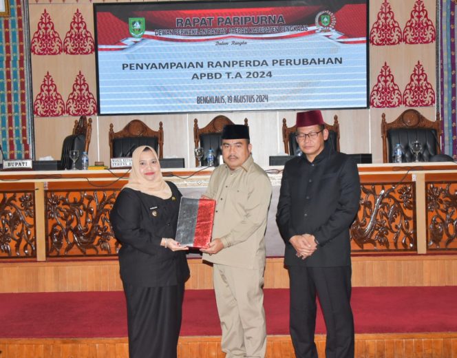 
 📸 Bupati Bengkalis, Kasmarni menyampaikan Ranperda APBD Perubahan 2024 kepada pimpinan rapat, Sofyan dan Syaiful Ardi.