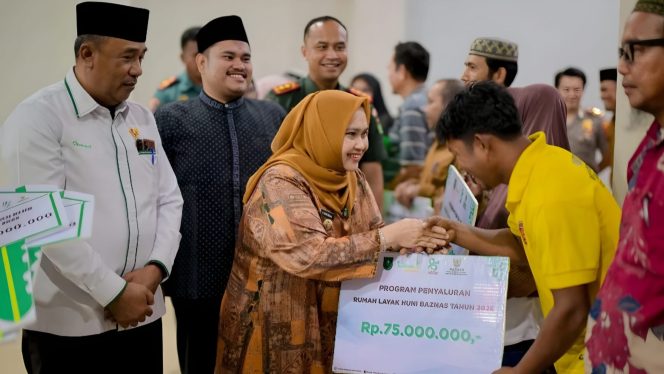 
 📸 Bupati Bengkalis Kasmarni didampingi Ketua DPRD, Septian Nugraha menyerahkan bantuan program rumah layak huni kepada warga saat Safari Ramadhan di Kecamatan Pinggir.