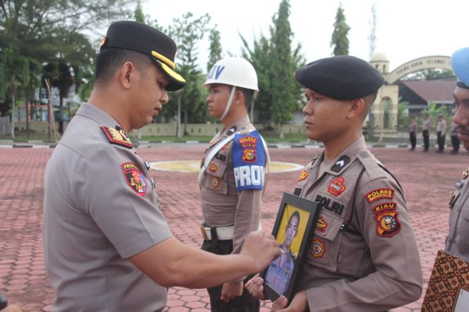 
 📸 Personel membawa foto bersilang Aipda Asmadi pada upacara pemberhentian tidak hormat di Polres Bengkalis, 2 Maret 2026.