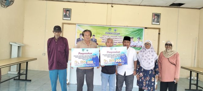 
 Pj. Kades Kelemantan Barat Mhd. Naser menyerahkan secara simbolis BLT DD tahap I kepda KPM
