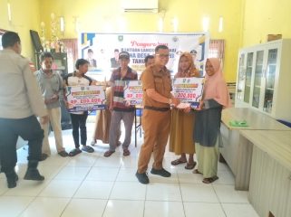Pj Kades Sungai Barang Budiman SE MM saat menyerahkan BLT DD kepada sejumlah KPM