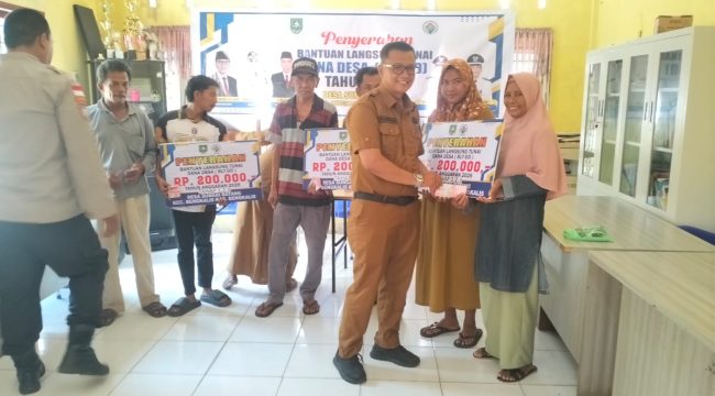 Pj Kades Sungai Barang Budiman SE MM saat menyerahkan BLT DD kepada sejumlah KPM
