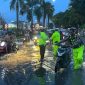 Personel Ditlantas Polda Riau bersama Satlantas Polresta Pekanbaru mengatur arus lalu lintas setelah hujan deras menyebabkan genangan di Jalan Jenderal Sudirman, Pekanbaru, Senin (20/7/2026).